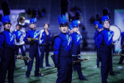 A MEMORABLE ENDING: Freshman, Kevin Li strikes a final pose at the finale of the Raptor Band marching show. This was the bands first full run of the show with props and special effects. photo by Kayla Le.