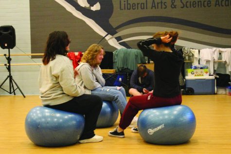 CIRCLE UP! Yoga students sit on yoga balls before class. At the start of class, students like to take time to warm up and stretch so they are ready to move for the rest of class. Photo by Sarah Garrett