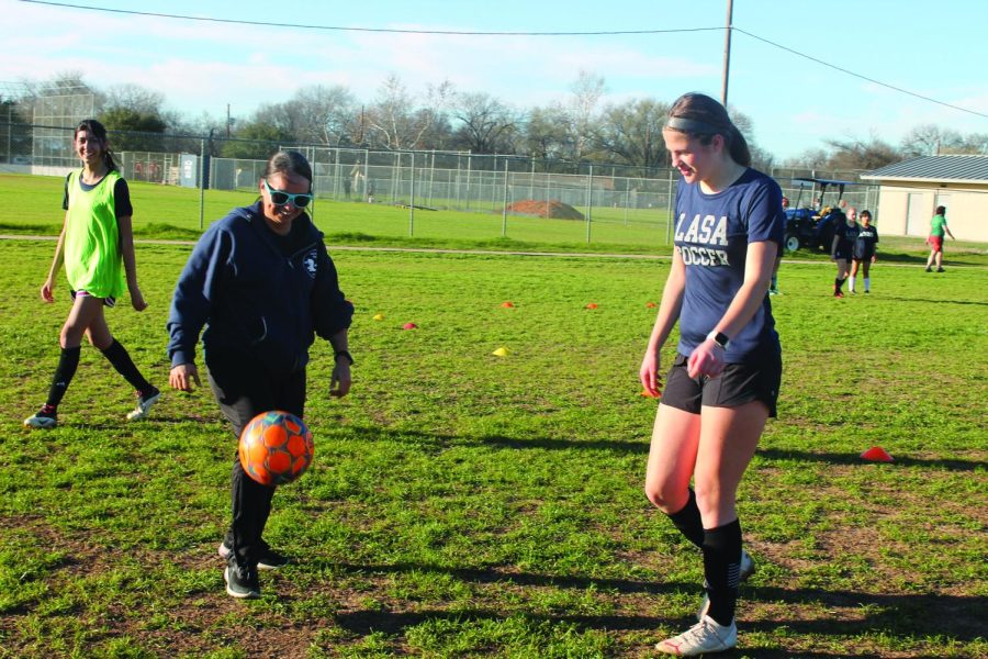 TALKING WITH YOUR FEET Girls soccer coach and tennis coach Alicia Salinas shows soccer player how to juggle the
ball. Salinas, who is one of LASA’s welness counselors, coaches
alongside Chloe Cardinale, one of the Great Ideas teachers. photo by Kayla Le