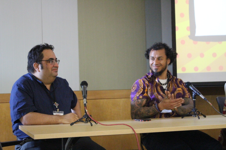 Enrique Garcia (left) and Darren Lopez (right) talk at a panel titled “Realism in Futurism: Gods, Tricksters & Superheroes!” Garcia is a  professor at Middlebury College and Lopez is an author. photo by JC Ramirez Delgadillo