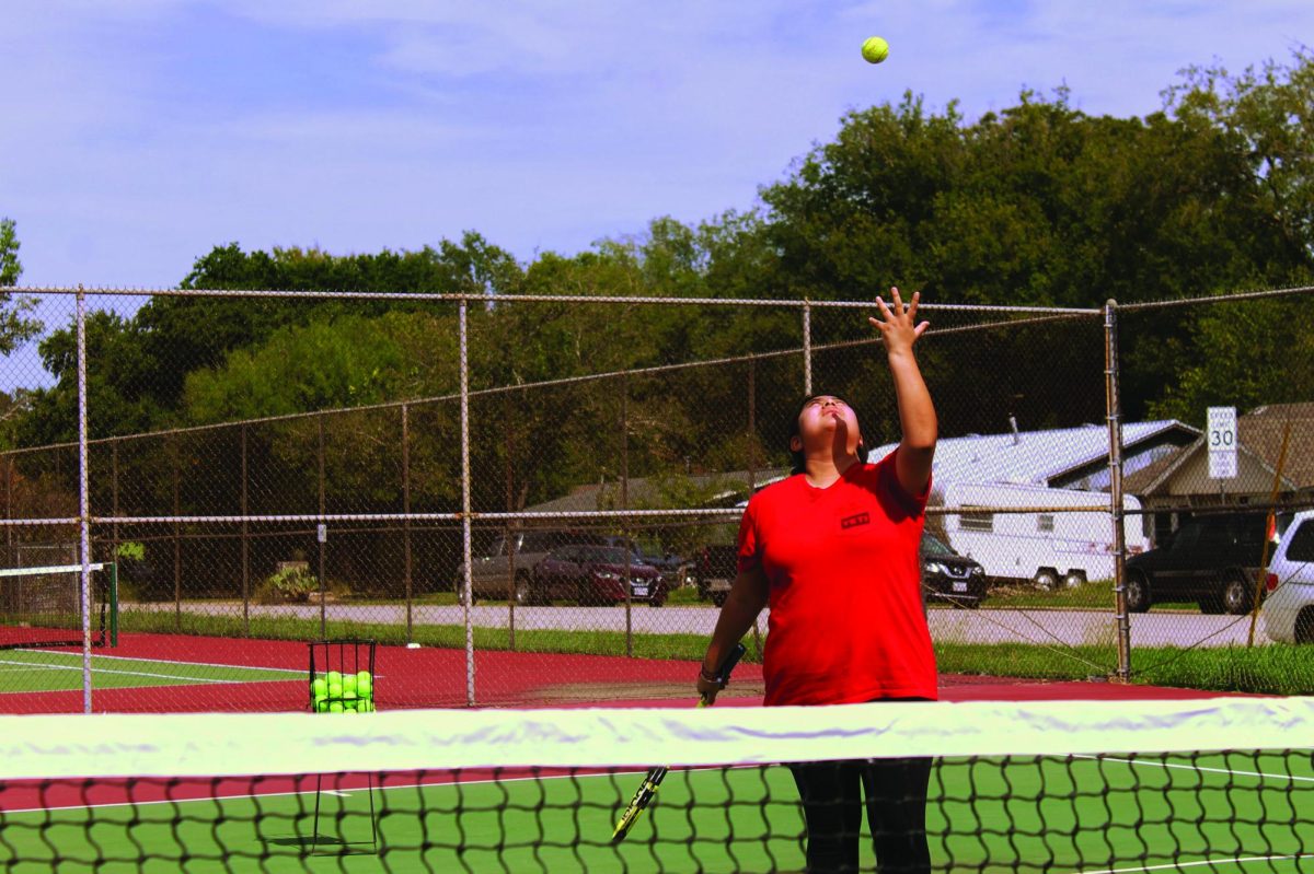 TENNIS, ANYONE? | Finance editor Alex Valencia-Serrano tosses up the tennis ball as she prepares to serve. Through her brief time with the LASA tennis team, she learned some tricks on proper serving form.