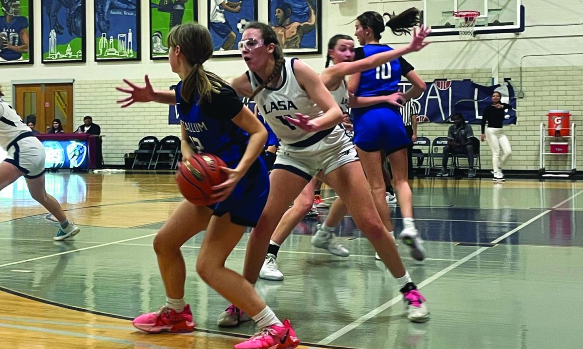 GUARD | LASA senior Lyssa Lashus prevents McCallum freshman Ruby Airhart from passing the ball. Both the girls and boys basketball teams finished their 2023-2024 seasons with their best records yet.