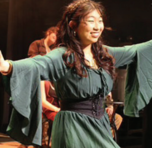 UNDER THE LIGHTS: Senior Natalie Choi performs “Livin’ it Up on Top” with a smile. Choi’s role in Hadestown” was Persephone, the Greek goddess of grain and agriculture and thewife of Hades.