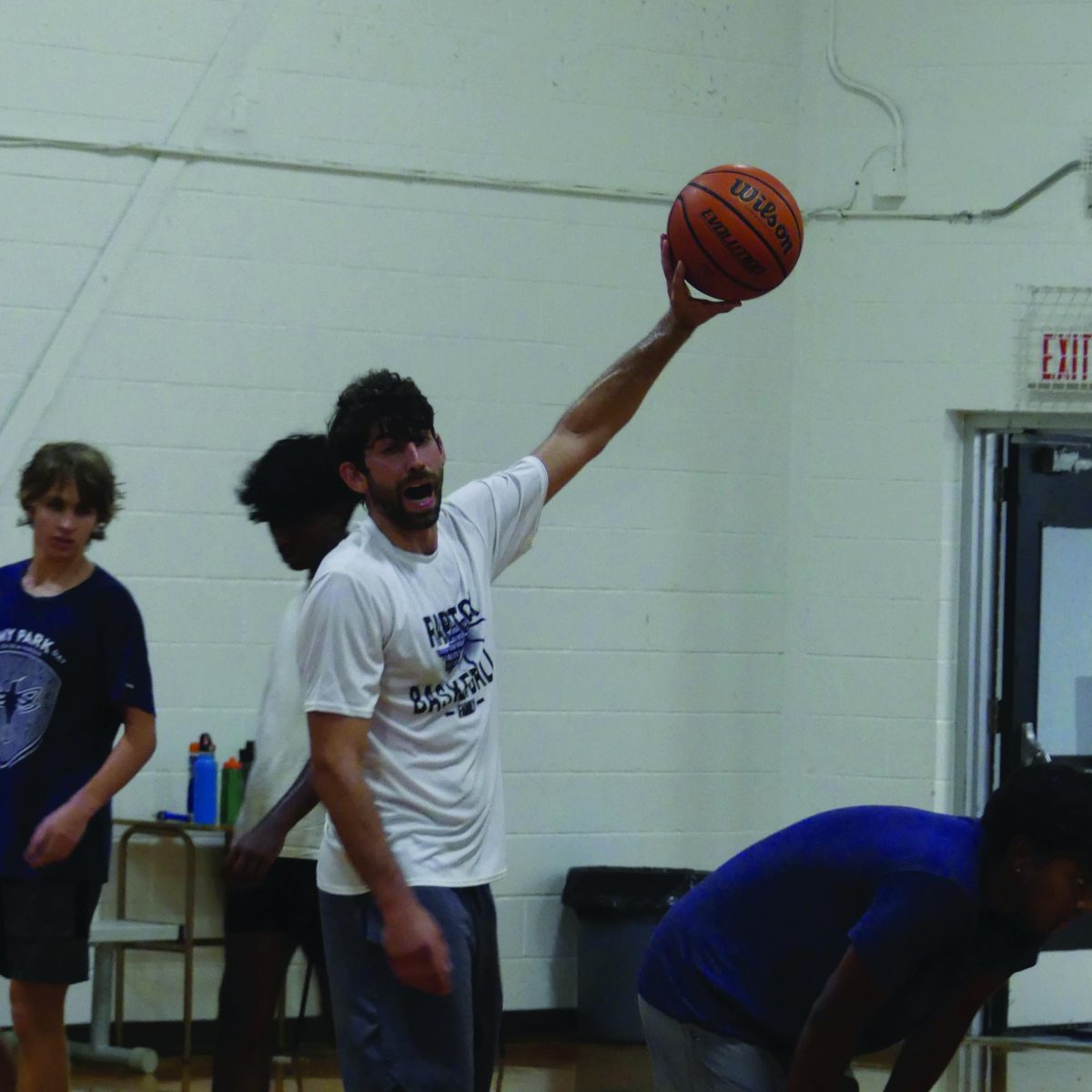 WATCH AND LEARN Coach Nelson mentors boys basketball during a practice match. Nelson hopes to inspire his players and continue building up a sense of unity in the team.
