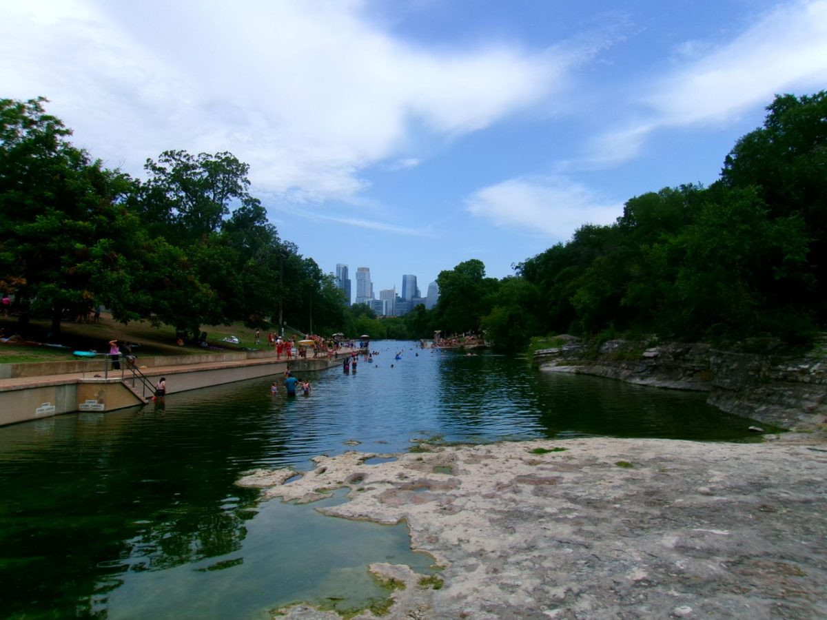 BARTON SPRINGS SKYLINE People at Barton Springs doing various activities on each side and swimming in the water. Barton Springs on a week day in the summer. 