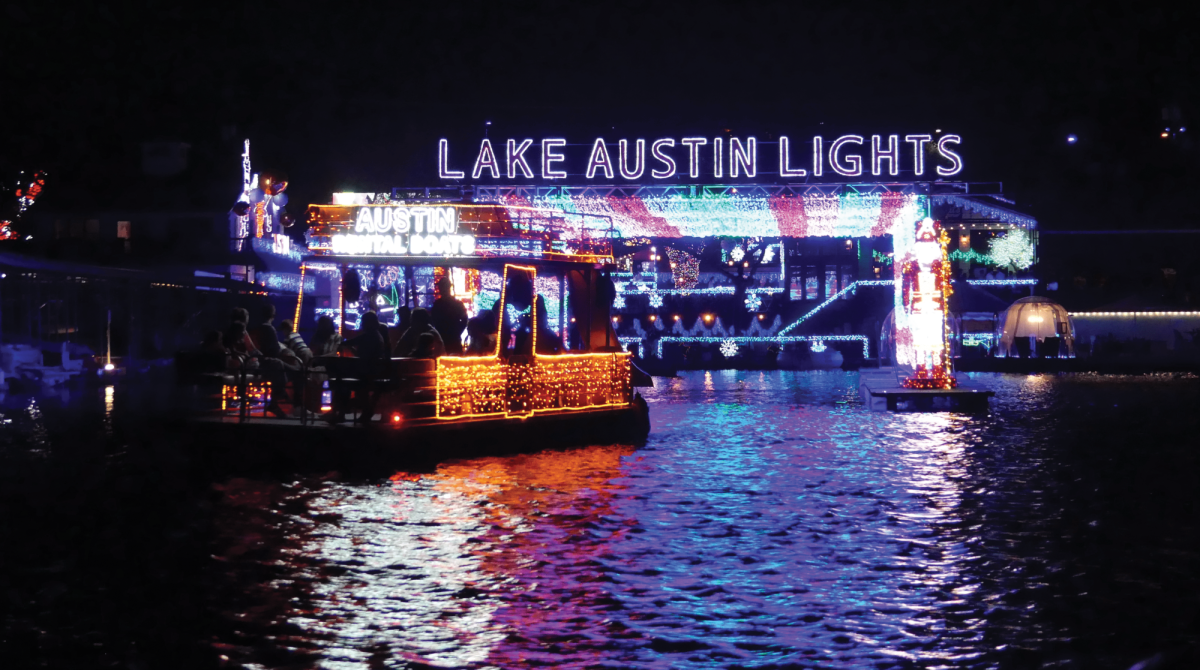 AUSTIN BOAT RENTAL LAKE AUSTIN FESTIVAL OF LIGHTS Arch of lights floating on Lake Austin. Guests go on a tour of the lights during a boat ride.